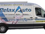 the van is white and has a blue and white advertisement on the side of it