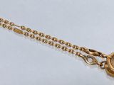 un gros plan d'un collier en or orné d'un médaillon