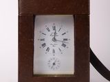 a small brown clock with roman numerals on it