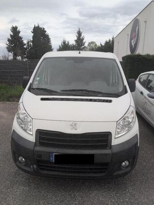 a white van parked next to a white car in a parking lot