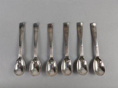 six silver spoons are lined up in a row on a table