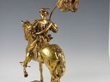 an antique bronze statue of a man on a horse holding a flag