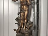 a bronze statue of a child on a pedestal
