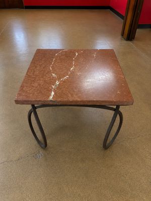une petite table avec un plateau en marbre dans une pièce