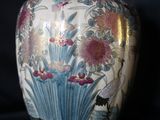 un vase orné de fleurs, posé sur une surface noire