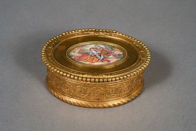 a gold box with a picture on it on a table