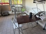 a table and chairs in a room with a picture on the wall