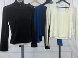 three shirts hanging on a clothes rack in a room