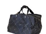 le grand sac noir est posé sur une surface blanche