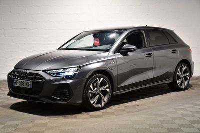un SUV Audi gris garé devant un mur de briques blanches