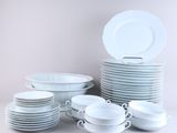 a lot of white plates and bowls on the table