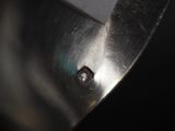 a close up of a piece of metal with a hole in it