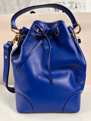 a blue bucket bag sitting on top of a white table