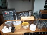many plates and bowls on a wooden shelf