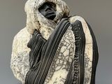 a black and white sculpture of a person holding a bag