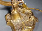 a gold colored lamp with a bird on top of it