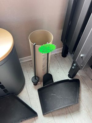 a black trash can and a black trash can next to a radiator
