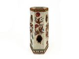 un vase blanc orné d'un motif sur fond blanc