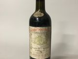 une bouteille de vin rouge posée sur une table blanche
