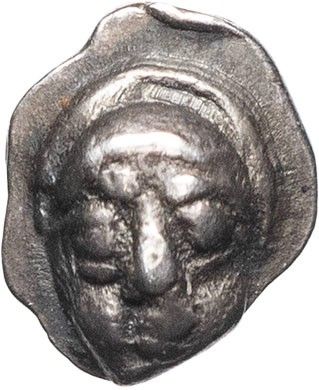 a close up of a silver coin with a face on it
