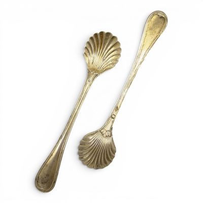 two spoons and a spoon rest on a white surface