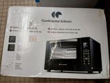 packaging of a black microwave oven sitting on top of a tiled floor
