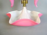 a pink and white bowl with a gold faucet on it
