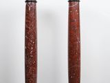 a pair of red marble pedestals sitting on top of a wooden floor