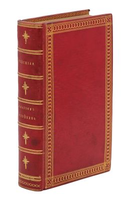 un vieux livre rouge aux tranches dorées, avec une croix sur la couverture