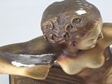 a bronze statue of a woman laying on top of a book
