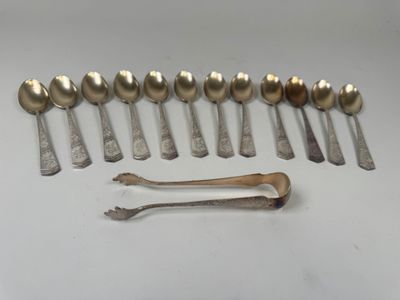 six cuillères et un repose-cuillère sur une surface blanche