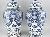 pair of blue and white vases with lids on a gray background