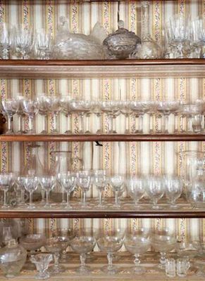 une étagère en bois sur laquelle sont posés de nombreux verres