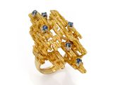 Gros plan sur une bague en or ornée de pierres bleues