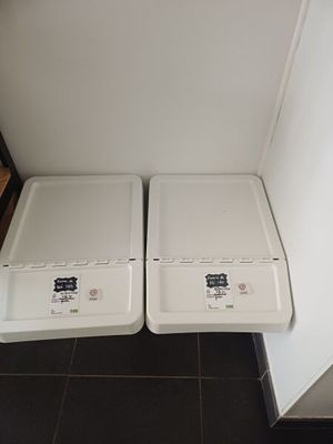 two white trash cans sitting next to each other on the floor