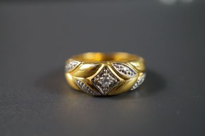 une photo d'une bague en or sertie de diamants posée sur une table