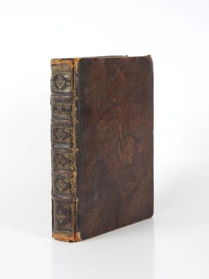 an old book with writing on it sitting on a white surface