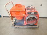 une soufflerie orange posée sur un chariot dans un garage