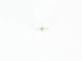 une photo d'une bague sertie d'un seul diamant posée sur une surface blanche