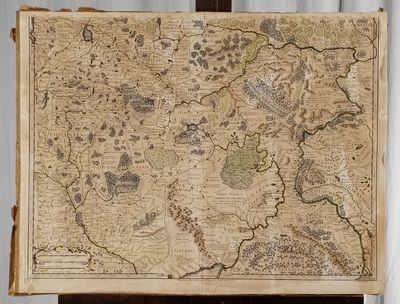 an old map on a wooden easel with a curtain in the background
