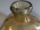 a clear glass vase with a black label on it