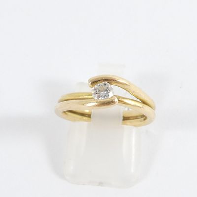 a close up of a gold ring with a diamond on top