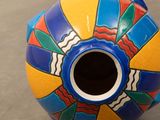 a colorful vase sitting on a table on the floor