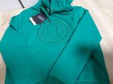 a close up of a green hoodie with a smiley face on it