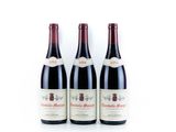 trois bouteilles de vin rouge posées sur une table blanche