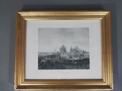 une photographie de paysage encadrée dans un cadre doré, accrochée à un mur gris