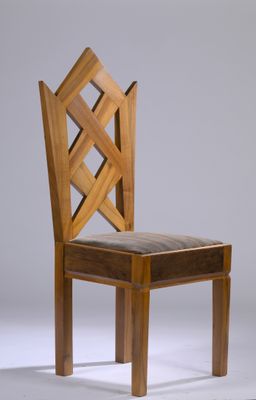 a wooden chair with a leather seat on a white surface
