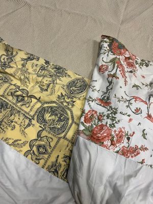 two pillows that are sitting on a bed together