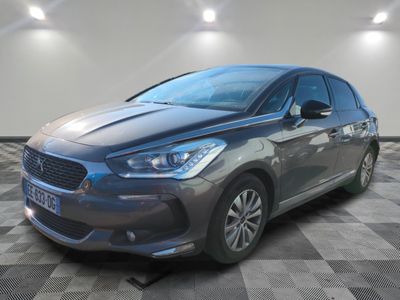 une voiture grise garée dans une pièce au sol en damier