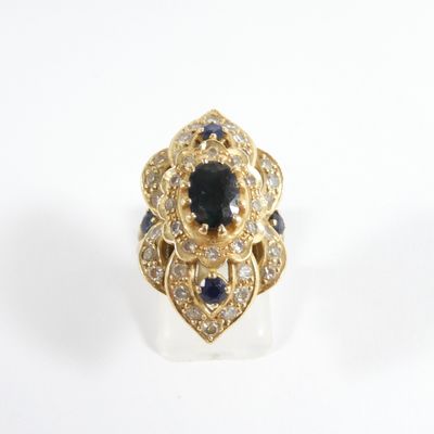 une photo d'une bague sertie d'un diamant et d'un saphir sur un fond blanc